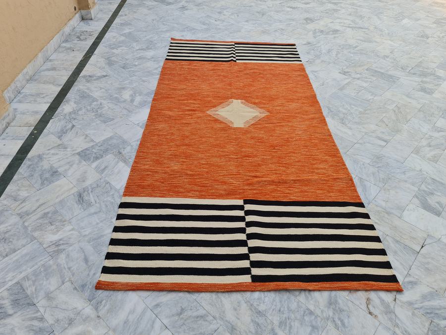 Custom flatweave kilim rug in orange and black, woven to order by Rug Gossips in Lahore