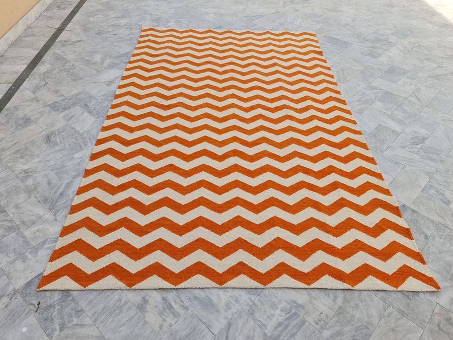 Custom flatweave kilim rug in orange and white zigzag, woven to order by Rug Gossips in Lahore