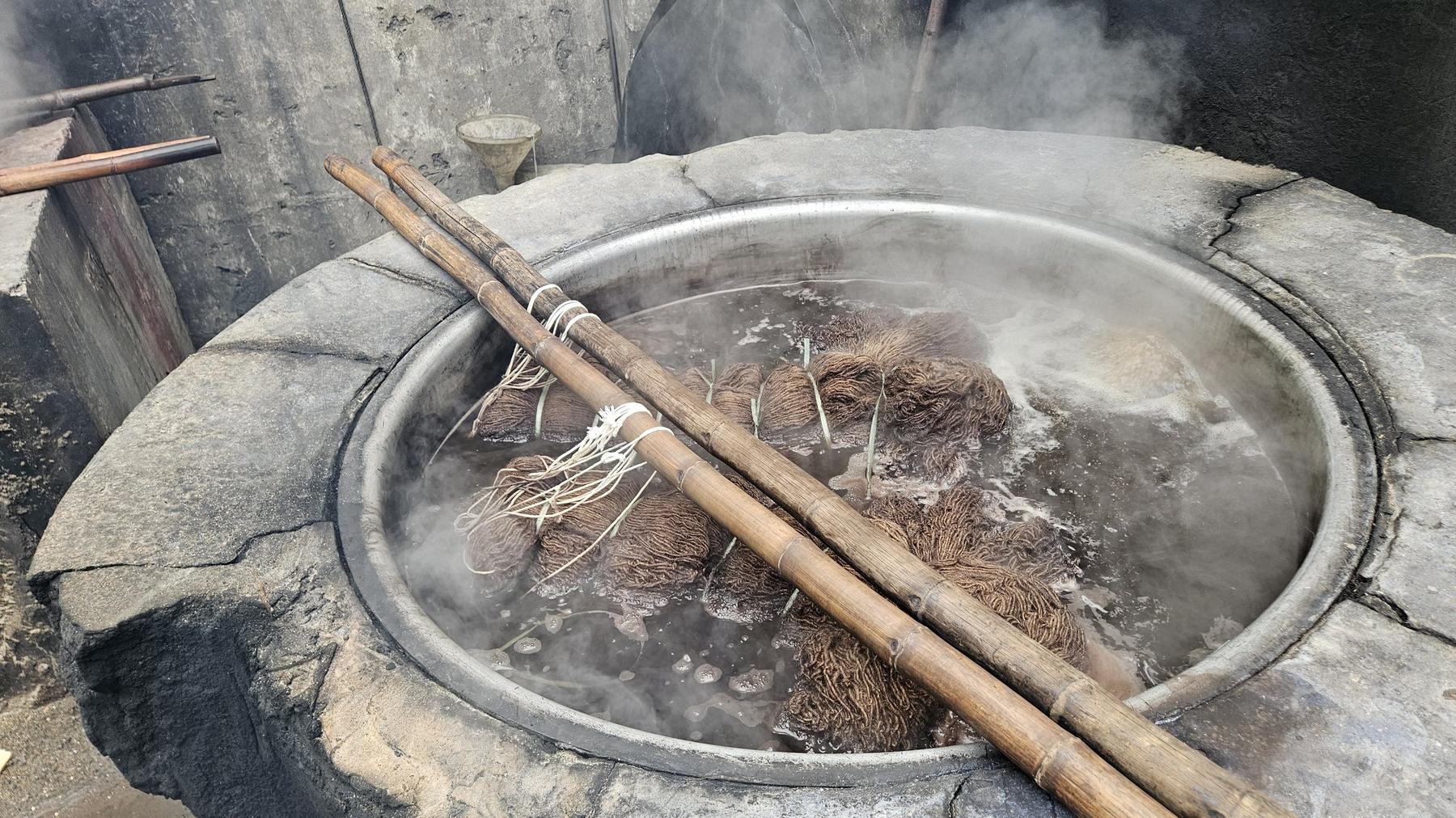 Wool submerged in a steaming dye vat in the Rug Gossips dye house, Lahore