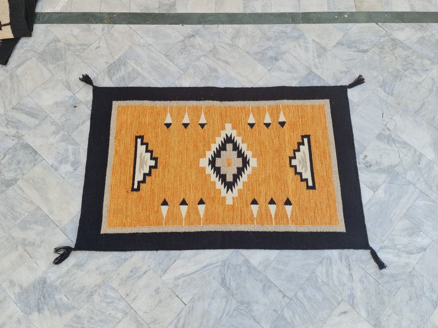 Custom Southwestern Navajo-style flatweave rug in orange and black navajo, woven to order by Rug Gossips in Lahore
